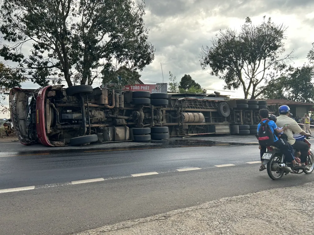 Xe đầu kéo lật nghiêng dầu chảy lênh láng trên mặt đường. Ảnh: VŨ LONG Xe đầu kéo lật nghiêng dầu chảy lênh láng trên mặt đường. Ảnh: VŨ LONG