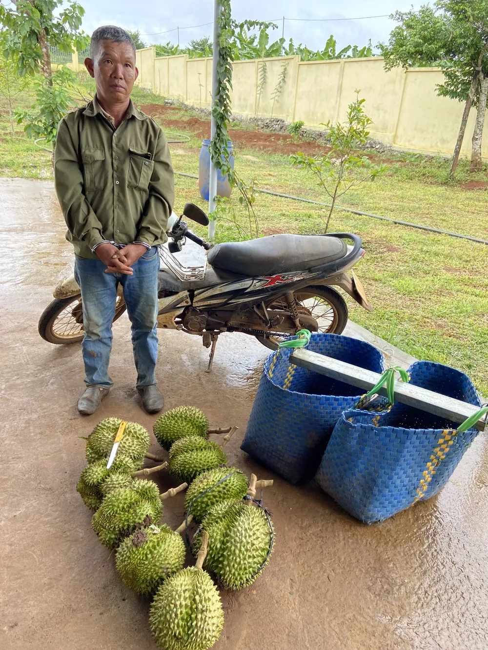 Bị can Hiển và tang vật là 9 quả sầu riêng. Ảnh: AX hien-va-tang-vat.jpg