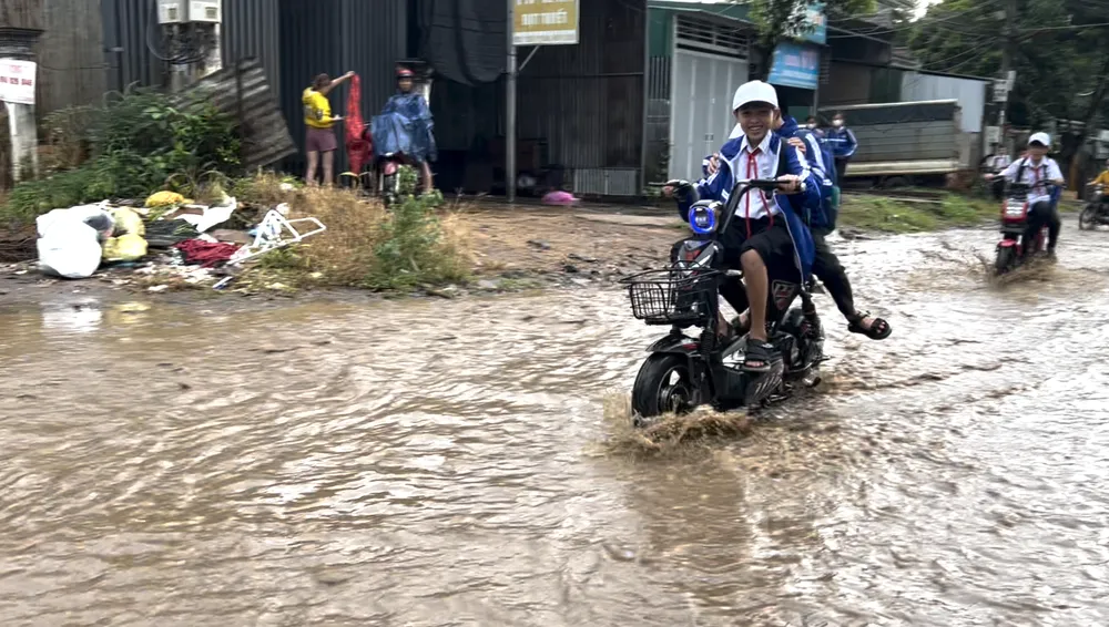 Học sinh đi trên đường ngập nước. Ảnh: VL Đường Phan huy Chú