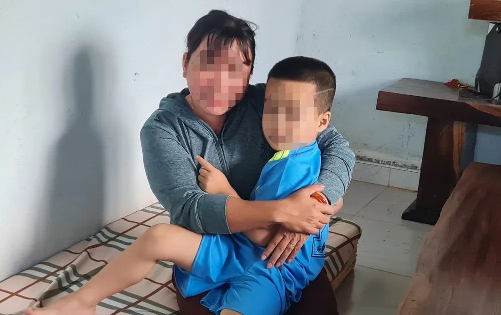 Bé trai 4 tuổi trong vòng tay của Chủ tịch Hội phụ nữ xã Hòa Xuân. Ảnh: TD tim-nguôi-nha.jpg