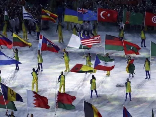 Các tình nguyện viên cầm cờ các quốc gia tham dự