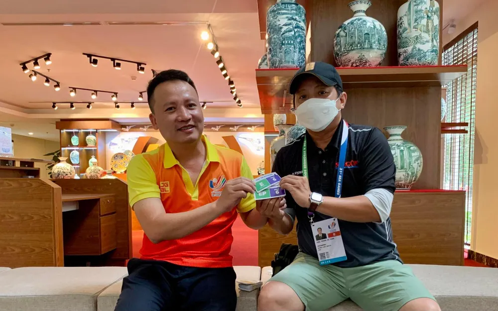 Phóng viên Dũng Phương (báo SGGP) nhận "giấy phép con" từ anh Nhật Đoàn, cán bộ truyền thông của VFF. Ảnh: A.P Phóng viên Dũng Phương (báo SGGP) nhận "giấy phép con" từ anh Nhật Đoàn, cán bộ truyền thông của VFF. Ảnh: A.P