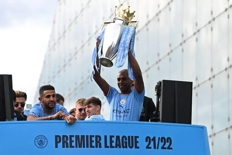 Fernando nâng cao chiếc cúp vàng. Robben Dias ăn mừng danh hiệu. ...Nhưng bao giờ thành cổ Manchester mới chứng kiến ngôi vô địch Champions League của Man. xanh? Nếu phía dưới chữ Champions...là Champions League thì hoành tráng hơn. Những cầu thủ Man. Xanh thật...điệu đà.