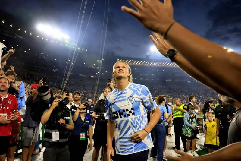 Haaland chào khán giả trên sân Lambeau. Mùa hè này hàng loạt ông lớn châu Âu đến Mỹ để đá giao hữu với nhau. Grealish &quot;không chiến&quot; với hậu vệ Nianzou của Bayern. Các sân bóng Mỹ mùa hè này chào đón những Bayern, Man. City, Barcelona, Real Madrid... Haaland ghi bàn duy nhất trận giúp Man. City thắng &quot;Hùm xám&quot; 1-0. Nếu còn khoác áo Borussia Dortmund, Haaland và đồng đội dễ gì đánh bại &quot;Hùm xám&quot; Bayern.