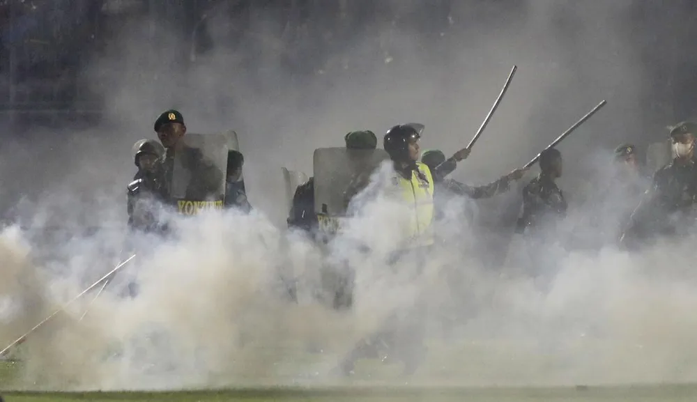 Cảnh sát Indonesia đang điều tra vào việc ai ra lệnh bắn hơi cay và bom cháy vào đám đông trong sân, vi phạm quy định trận đấu của FIFA. Nhiều người đập cửa gió thông thoáng để thoát hơi cay và bom cháy trong sân. Tổng thống Widodo và Chủ tịch LĐBĐ Indonesia, Tướng Mochamad Iriawan xem xét sân Kanjuruhan sau thảm kịch. Sân Kanjuruhan sau vụ thảm kịch. Tổng thống Widodo quan sát một lối thoát hiểm của sân Kanjuruhan. Có ba quan chức gồm trưởng ban tổ chức sân và hai quan chức phụ trách an ninh trật tự của sân Kanjuruhan đã bị kết tội. Thảm họa gây nên cái chết của 131 nạn nhân, thảm họa đứng thứ nhì về số người chết trong lịch sử bóng đá nhân loại. Ba cảnh sát đã bị bắt gồm người ra lệnh và hai cảnh sát khai hỏa hơi cay và bom cháy. Các đội tuyển Indonesia gồm tuyển Futsal và U-17 đang thi đấu nước ngoài đeo dải băng tang trên tay. Nhiều nơi ở Indonesia tưởng niệm nạn nhân xấu số của thảm kịch 1-10. La Liga Tây Ban Nha và CLB Real Madrid tiến hành phút mặc niệm tưởng nhớ nạn nhân vụ Kanjuruhan. Tướng Mochamad Iriawan, Chủ tịch LĐBĐ Indonesia đi bên cạnh Tổng thống Widodo. Ông Iriawan đang chịu áp lực dư luận buộc từ chức.