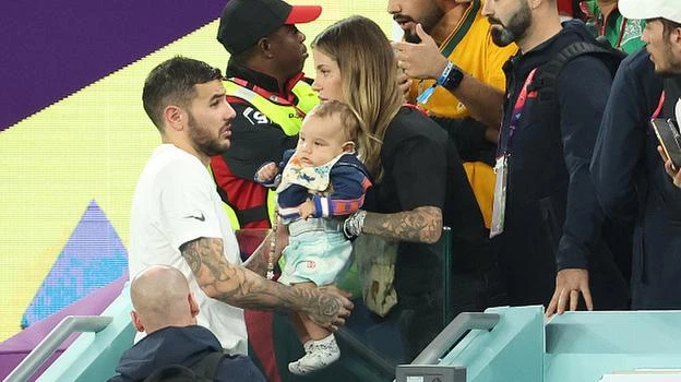 Sau trận thắng Úc 4-1, Theo Hernandez lên khán đài bế con trai. Siêu mẫu người Ý xăm trổ đầy mình. Ảnh: S.E