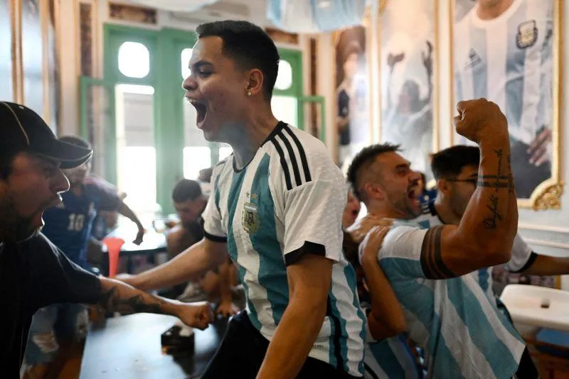 Các fan chúc mừng nhau khi Messi mở điểm từ chấm 11m, đây là hình ảnh tại Lo De Diego, Argentina. Ảnh: Reuters Tại thủ đô Buenos Aires của Argentina...mọi người thức dậy xem chung kết và ăn mừng. Ảnh: Reuters Tại một trung tâm văn hóa ở Buenos Aires. Ảnh: Reuters ...Còn trên sân Lusail, nơi diễn ra trận chung kết có khoảng 10 ngàn người Argentina, không kể fan của Argentina. Ảnh: Reuters