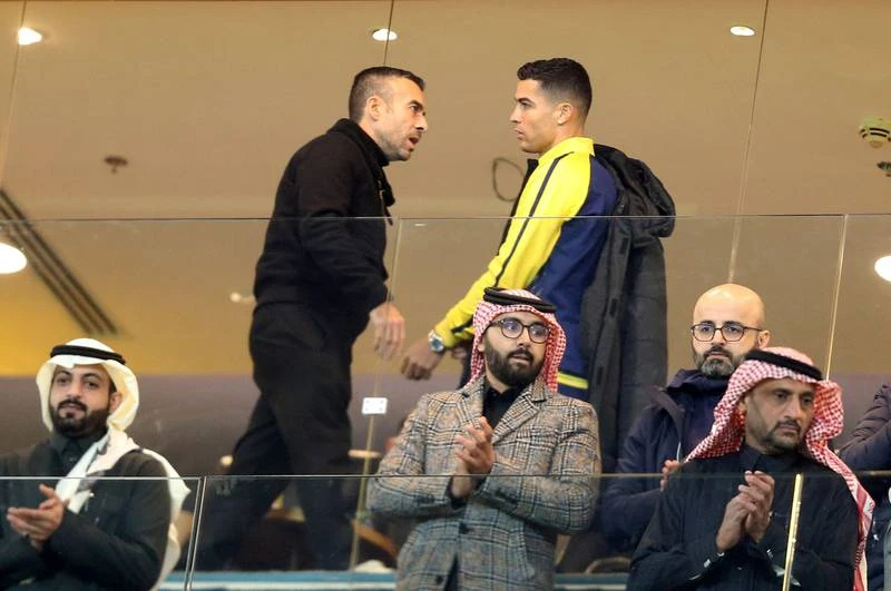 Ronaldo ngồi trên khu VIP của sân với các lãnh đạo Al Nassr. Một fan nữ tiến đến xin chụp hình chung với Ronaldo. ...OK, chụp nhé. Cho đến nay, áo chính hãng của Ronaldo đã bán được 50 ngàn chiếc. Ronaldo quan sát sân Mrsool qua cửa kính. Ronaldo chào fan khi hiện diện trên khu VIP.