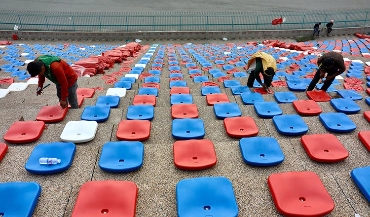 "Bóc tem" các ghế ngồi thô sơ bằng nhựa. Ảnh: CTP ...Công nhân dùng búa để bắt đinh gắn chặt ghế vào bê tông. Ảnh: CTP Khi vào bên trong sân Olympic ở Phnom Penh này cảm giác rất giống bên trong sân Cần Thơ. Ảnh: CTP Lắp đặt ghế tạm thời là hạng mục cuối cùng của sân Olympic chờ ngày 29-4 quả bóng môn bóng đá SEA Games 32...lăn. Ảnh: CTP