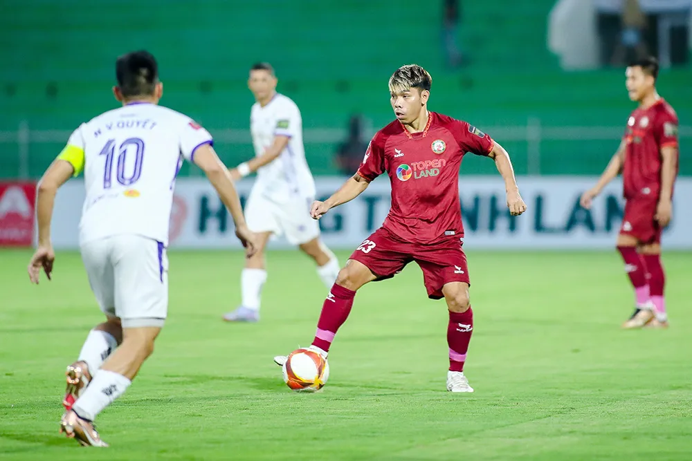 Văn Quyết (10) trong pha đối đầu với Cao Văn Triền trên sân Quy Nhơn chiều 17-4. Ảnh: VPF