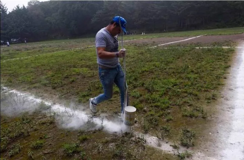 Một nhân viên của sân đang rải lại lằn vôi sân bằng chất bột trắng. Ảnh: AFP