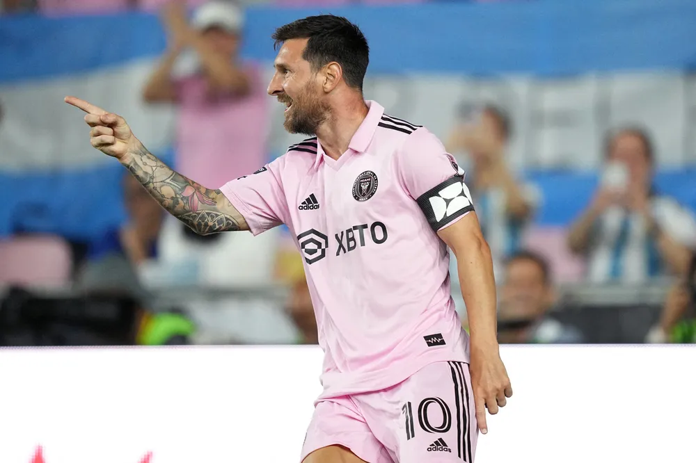 Về đội bóng mới Inter Miami, cứ ra sân là Messi... nhả đạn. Giải Mỹ đang mùa đá League Cup, Messi góp cú đúp vào lưới Atlanta Utd, rồi cú đúp vào lưới Orlando Utd. Một cơn mưa cực lớn đổ xuống sân trước trận Inter Miami-Orlando Utd ở vòng 1/16 League Cup. Lực lượng làm nhiệm vụ đẩy nước cho sân khô ráo. Mặt sân thấm nước nhưng không ngăn được &quot;cái que trái ma mị&quot; của Messi. ...Nhà vô địch thế giới lại ghi bàn vào lưới đối thủ. Đồng chủ tịch Beckham và phu nhân Victoria của Inter Miami rất hài lòng với tân binh Messi. ...Ghi bàn và &quot;làm dáng&quot; trước ống kính là điều dễ dàng với Messi ở Inter Miami. Messi khoe &quot;sáu múi&quot; sau trận thắng Orlando Inter Miami như bừng tỉnh khi Messi đến thi đấu cùng đồng đội cũ Jordi Alba. Nội đồng hương của Messi ở Florida không thôi là sân của Inter Miami không thể chứa đủ khi đội thi đấu sân nhà. Người bạn thân cùng thời của Messi là Aguero cho rằng Messi đến Mỹ là thể... thư giãn vì tuổi cao đá ở châu Âu áp lực quá lớn. Hình tượng Messi đang truyền cảm hứng mạnh mẽ tới những em nhỏ gốc La tinh ở Florida tìm đến bóng đá. Sau khi ông bố Messi...diễn và ghi bàn, cuối trận là các con trai của Messi cũng diễn trên sân.