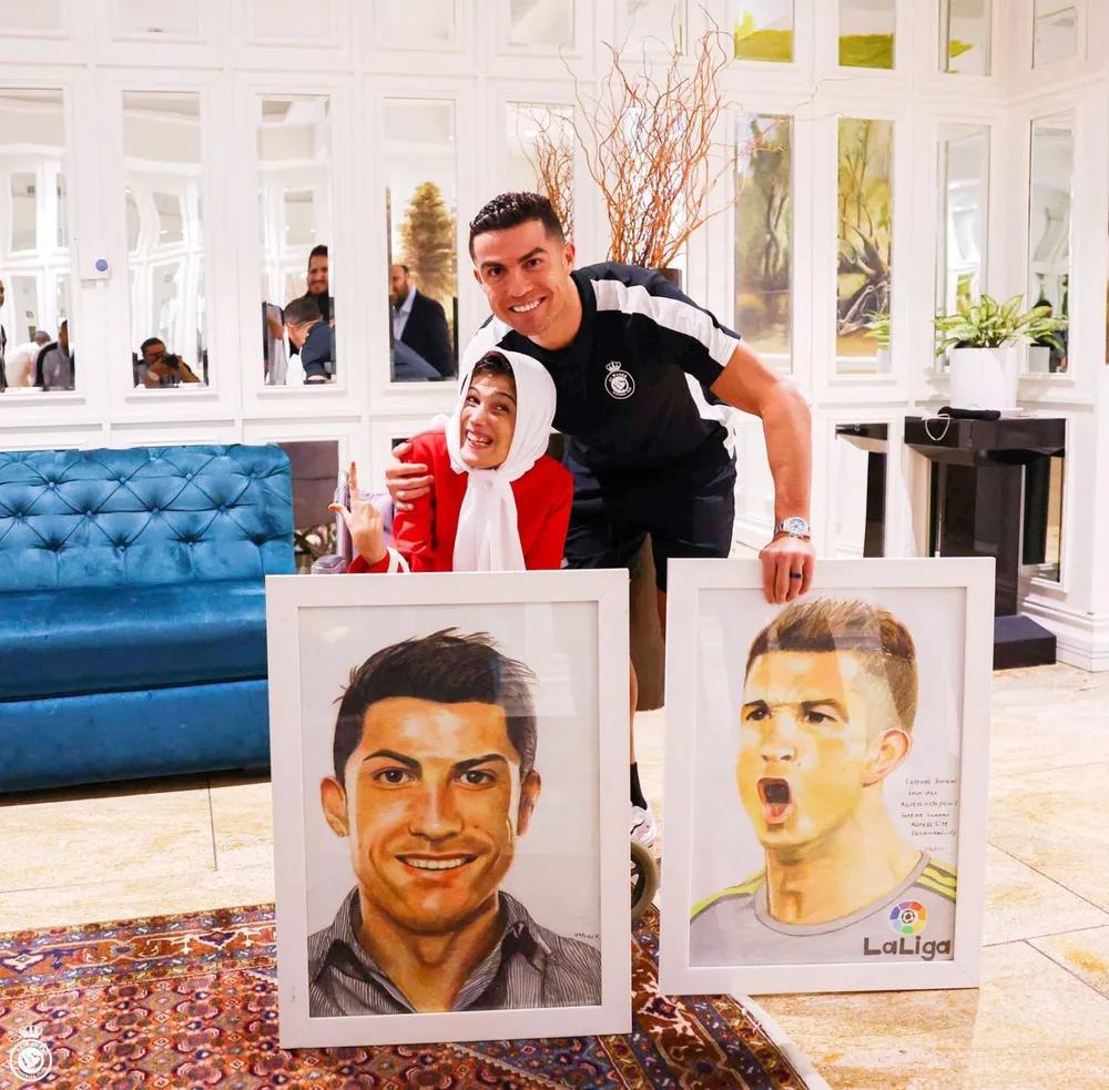 Ronaldo cùng họa sĩ Fatemeh và các tấm chân dung. Ảnh: K.T Ronaldo-1.jpg