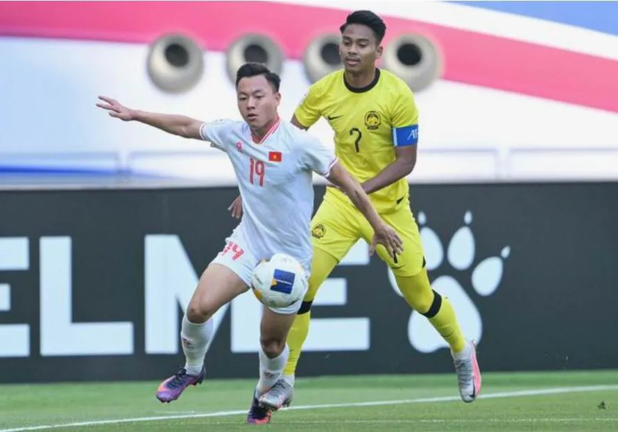 Thái Sơn đi bóng cùng sự đeo bám của Mukhairi Ajman. Ảnh: AFC Ma-vie-1.jpg