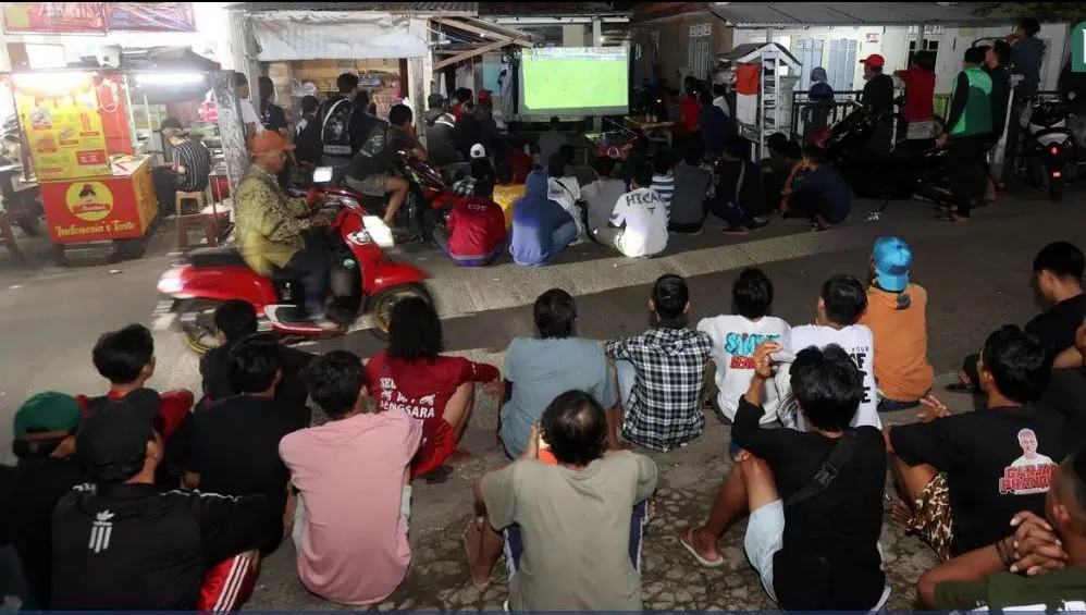 Quán xá ở Indonesia phục vụ fan hâm mộ qua truyền hình trực tiếp. Ảnh: Bola Play-off-2.jpg