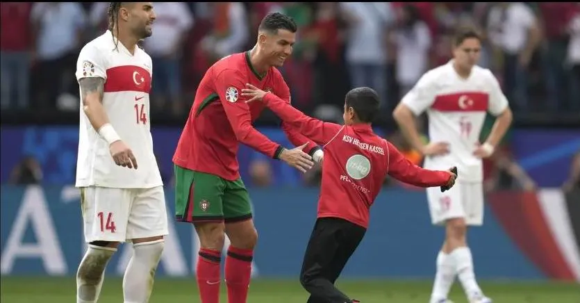 Ronaldo rất vui vẻ với fan nhí vi phạm này, có lẽ những bước chạy và "qua người" của cháu rất...điệu nghệ? Ảnh: AFP Ronaldo-bi-thay-mang-3.jpg
