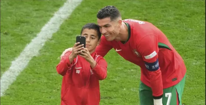...Và fan nhí đã thỏa mãn ước mơ của mình. Ảnh: AFP Ronaldo-bi-thay-mang-4.jpg