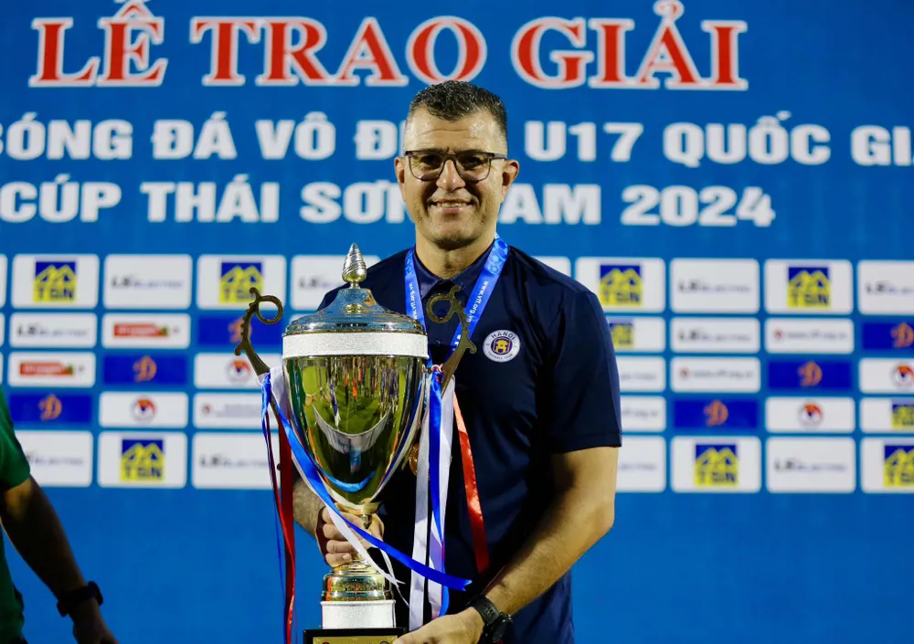 HLV Cristiano Roland của U-17 Hà Nội cùng chiếc cúp vô địch. Ảnh: CTP HLV Roland.jpg