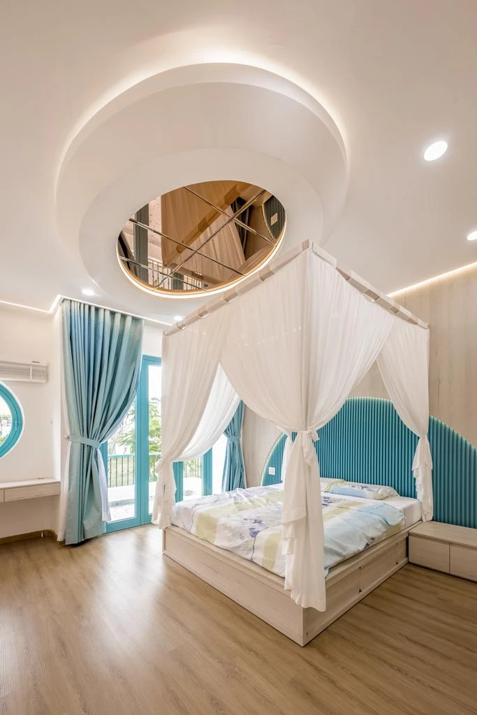 Trên đầu gường, kiến trúc sư sử dụng những thanh lam gỗ phủ sắc xanh pastel để tạo điểm nhấn, kết hợp cùng màu gỗ sáng, tổng thể không gian phòng ngủ rất dịu nhẹ, ấm cúng.