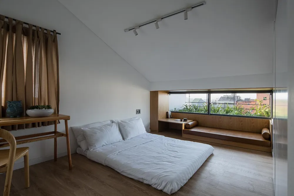 Phòng ngủ với gam màu vàng của sàn gỗ giúp không gian thêm sang trọng và hiện đại, tường trắng kết hợp thêm cửa sổ gam màu xanh mát nhìn ra view khá đẹp.