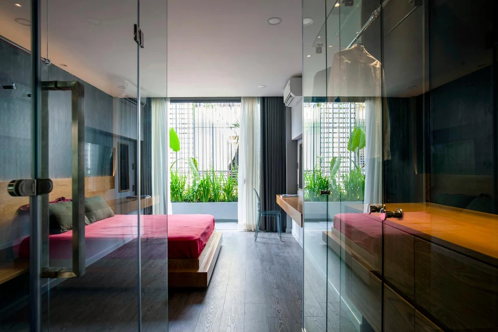 Phòng ngủ chính và phòng tắm đã được di dời ở khu vực phía trước của tầng hai và được thiết kế với kính lớn, sàn gỗ nhiều lớp và gạch đen.