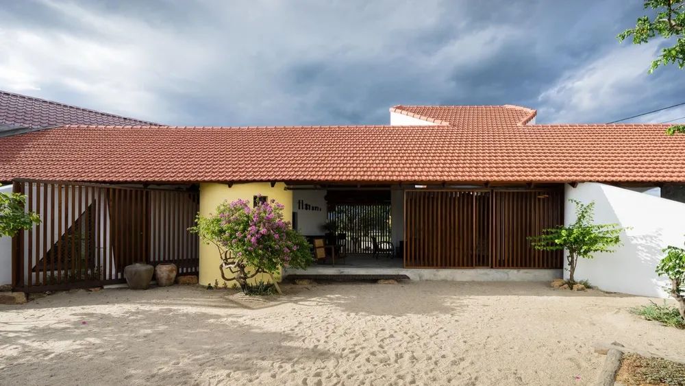 Ngôi nhà gồm một hệ mái dốc 45 độ, tạo ra một khoảng hiên rộng và hai mảnh vườn chéo góc.