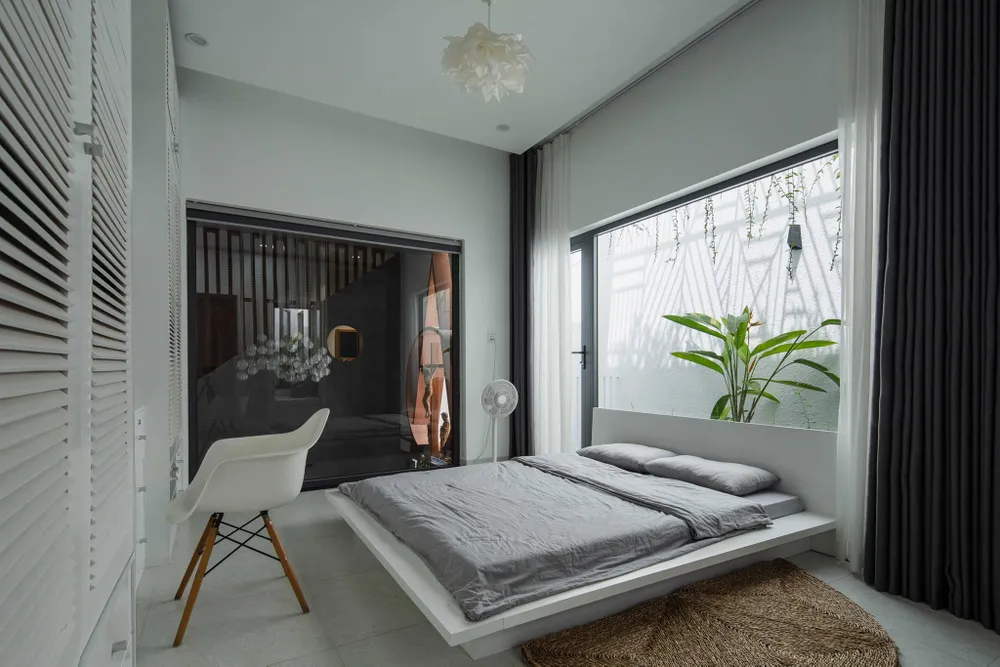 Không gian riêng tư được thiết kế với tông màu sáng, kết nối với khoảng thông tầng thông qua cửa kính trong suốt.