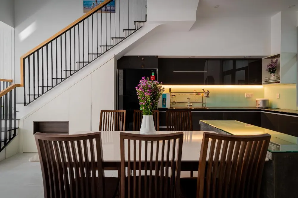 Chiều dài ngắn nên các kiến trúc sư đã tận dụng triệt để không gian dưới cầu thang để tăng chiều dài bếp và phòng kho.