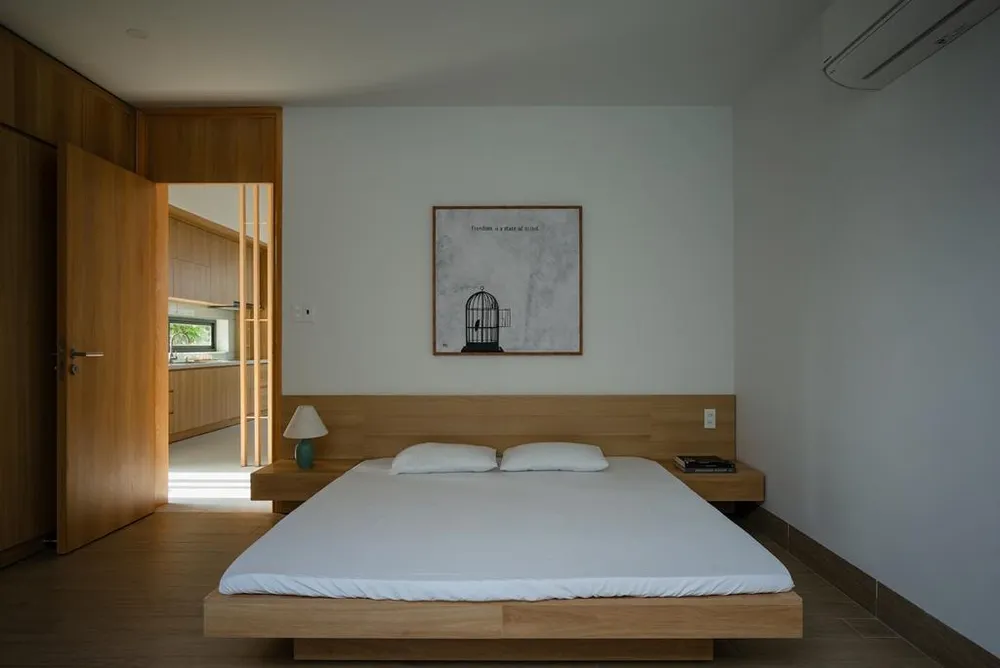 Vách ngăn bằng lam gỗ phân chia khu vực bếp và phòng ngủ.