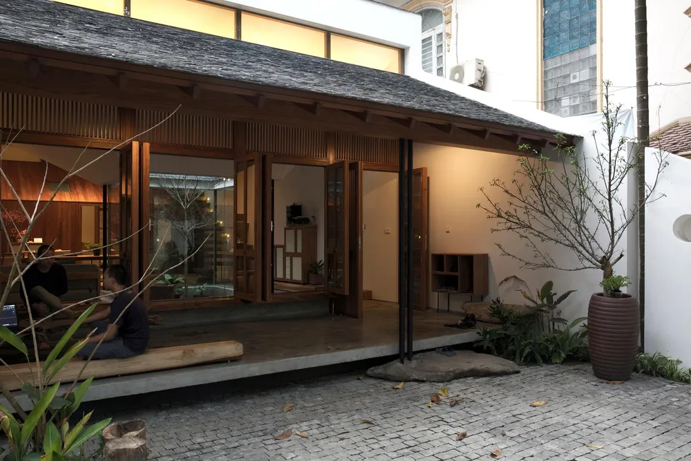 Khoảng sân rộng và toàn bộ cây xanh vài chục năm tuổi của ngôi nhà hiện tại được giữ nguyên giúp giữ sự riêng tư tối đa cho không gian mở bên trong.