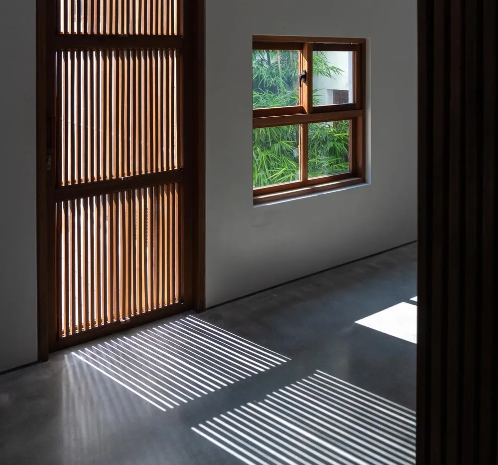 Những bóng đổ được tạo ra khi nắng lên từ cửa nan gỗ.