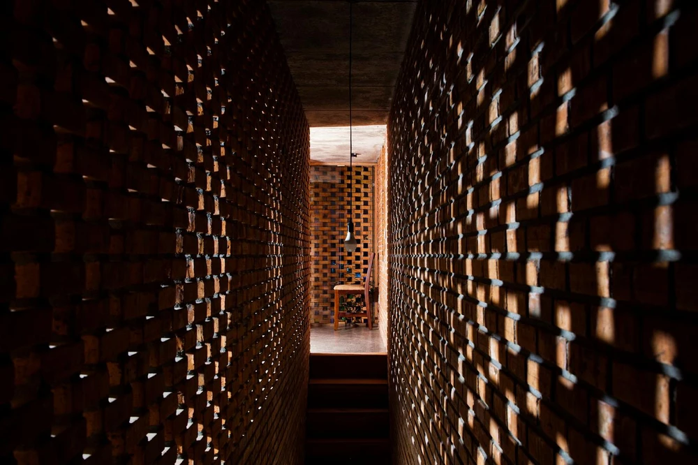 Vào ban đêm, ngôi nhà trông giống như một chiếc đèn lồng khổng lồ với những ánh sáng đèn xuyên qua những viên gạch nung.