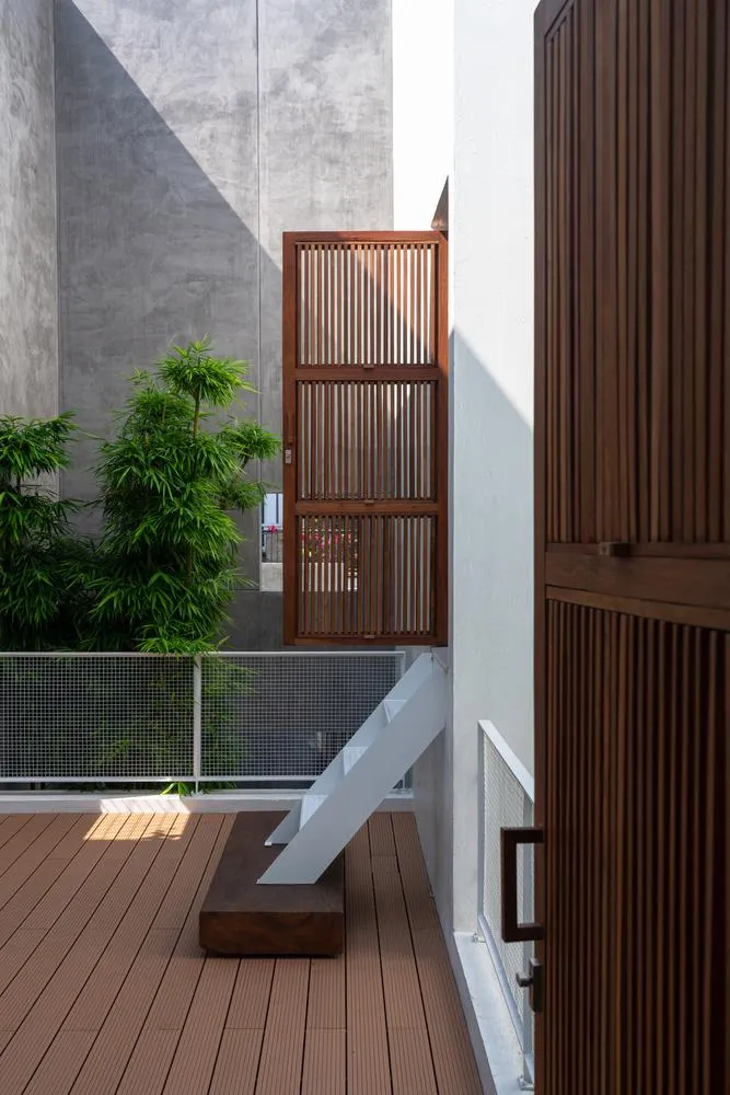 Bốn khối công năng và ba khoảng sân được gói gọn trong hệ thống tường bao cao 9 m tối giản với các ô cửa sổ.