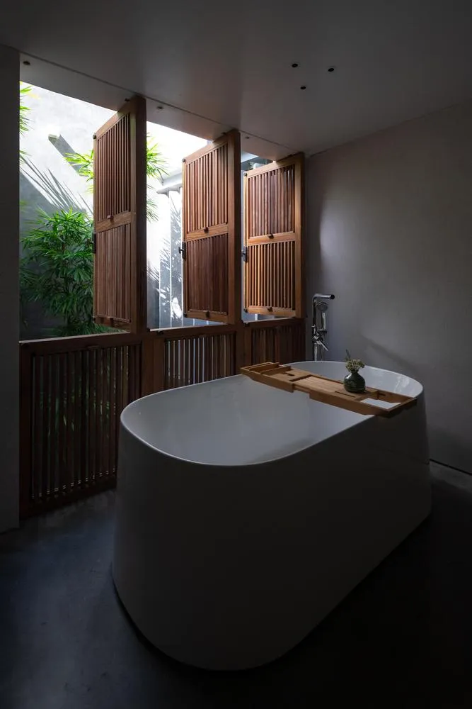 Phòng tắm mở thoáng ra khoảng sân vườn.