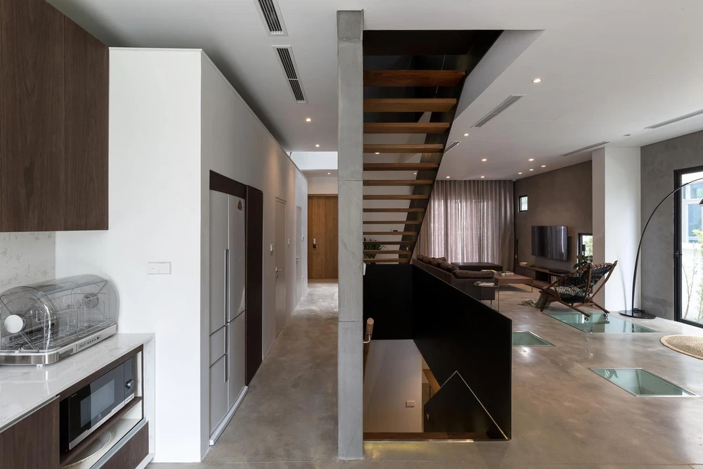 Bếp và không gian phòng khách ngăn cách bởi vách tường ngăn lối đi đến không gian riêng tư.