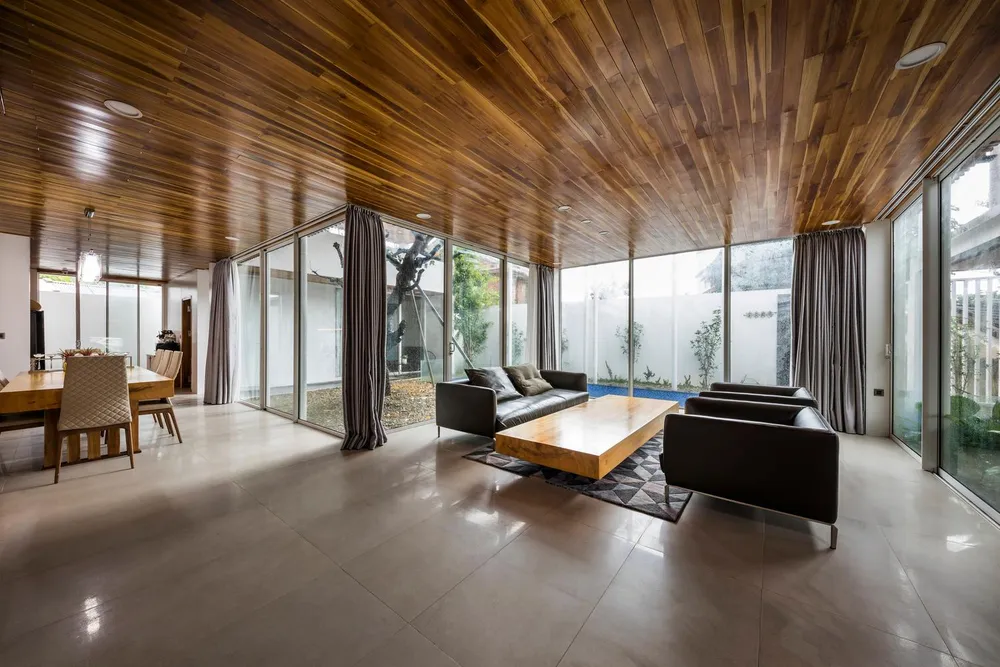 Phòng khách và bếp thiết kế gần nhau, hai không gian này đều hướng ra khoảng cây xanh bên ngoài giúp không gian sống trở nên thú vị hơn.