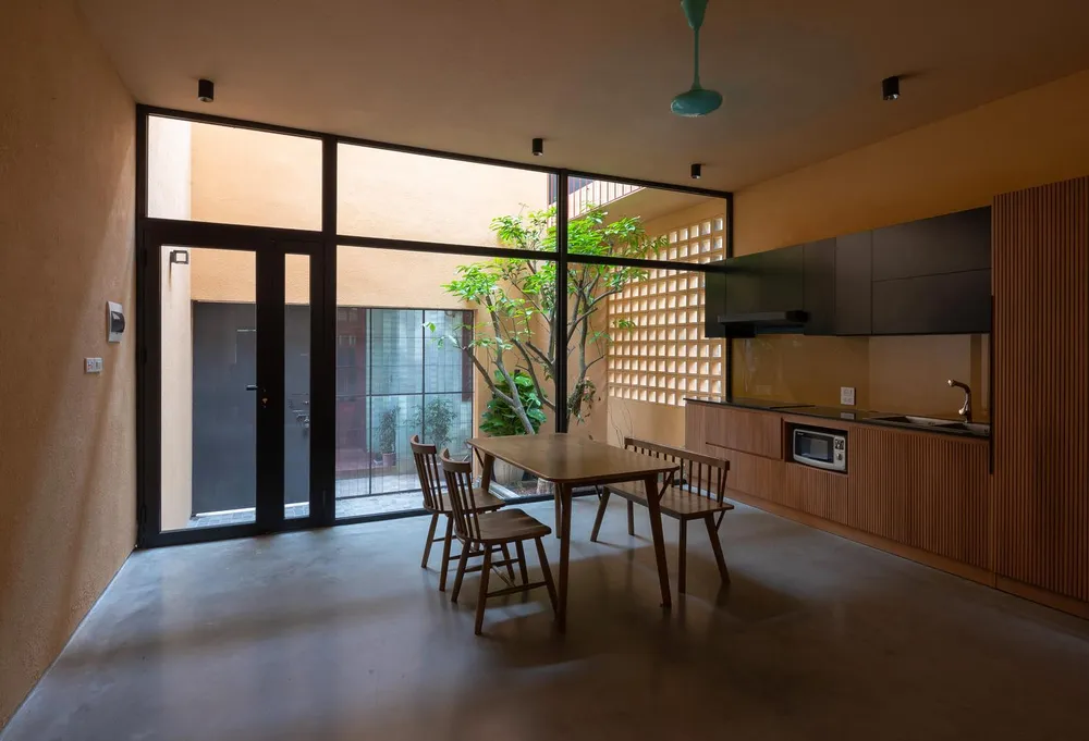 Bàn ăn lớn từ gỗ cùng tông màu với gian bếp.