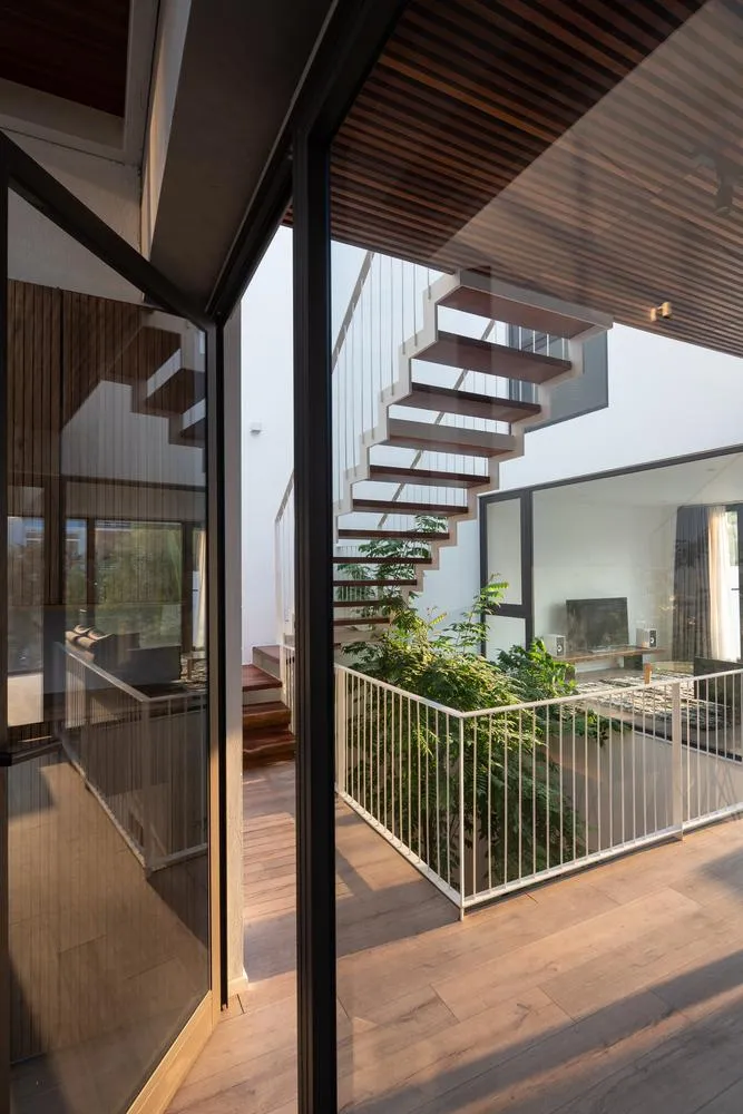 Cầu thang và giếng trời được thiết kế giữa nhà, kết nối các tầng trên và không gian riêng tư.