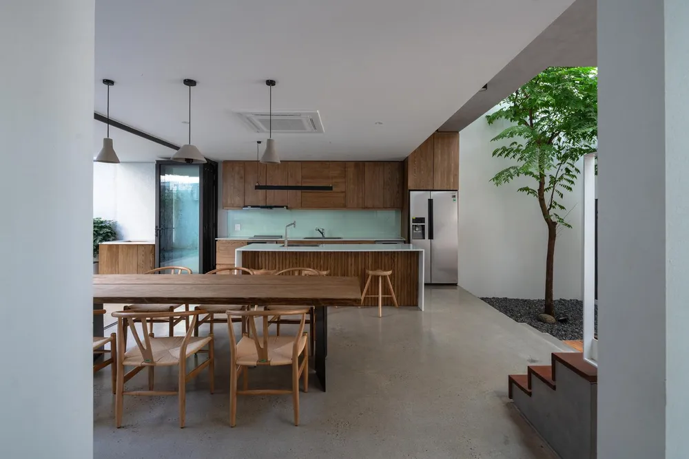 Bếp và bàn ăn nằm giữa hai khoảng sân trước và sân sau.