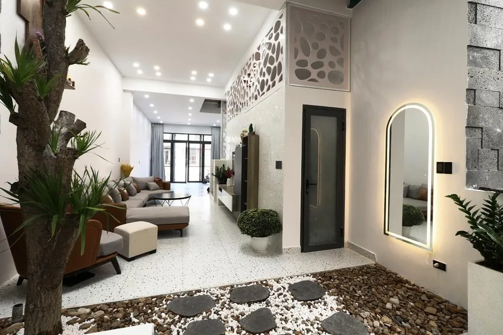 Kết nối giữa phòng khách và bếp là khoảng sân vườn nhỏ giữa nhà.