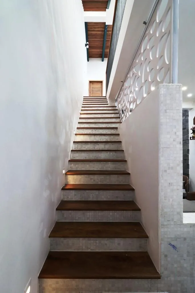 Cầu thang dẫn lên các tầng trên thiết kế đơn giản với gam màu tối.