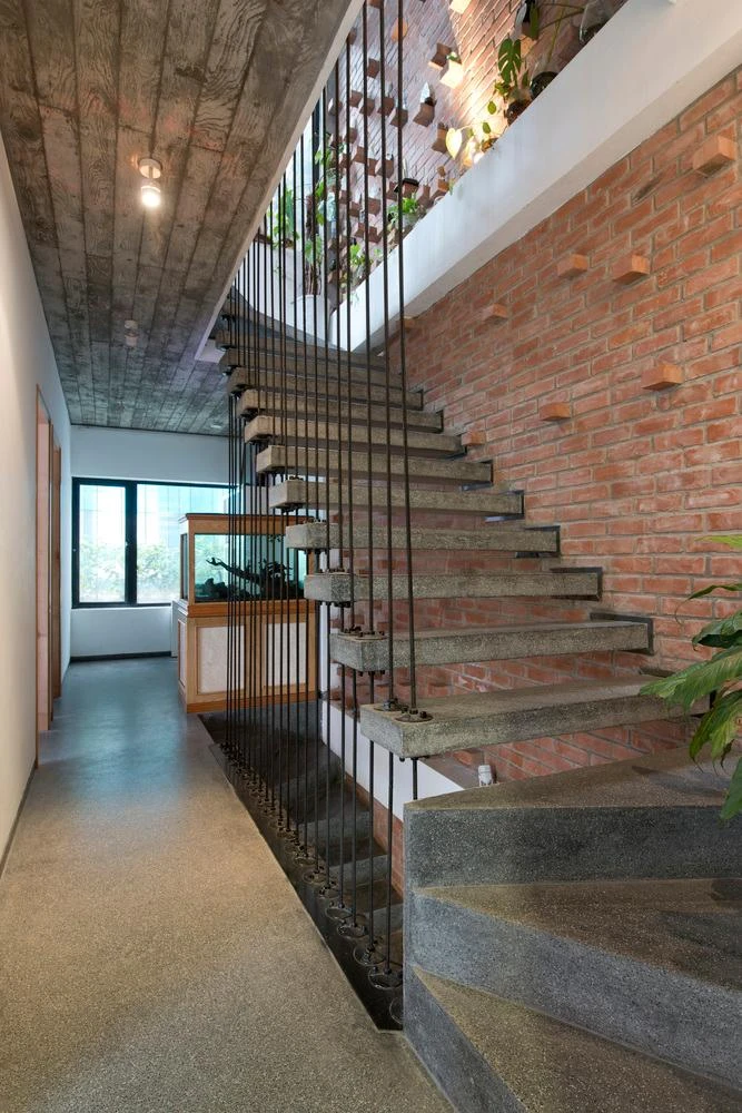 Cầu thang được sử dụng bằng những viên gạch thô, chen lẫn vào các không gian để tạo điểm nhấn và làm mát cho công trình.