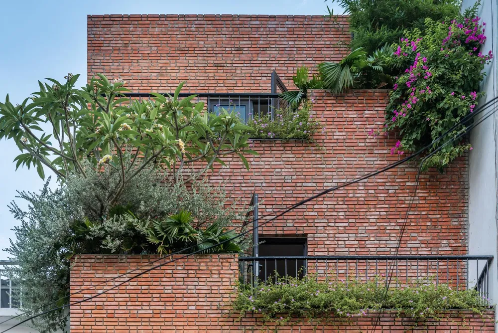 Những viên gạch mộc màu đỏ được ốp làm mặt tiền tạo sự thân thiện cho ngôi nhà.