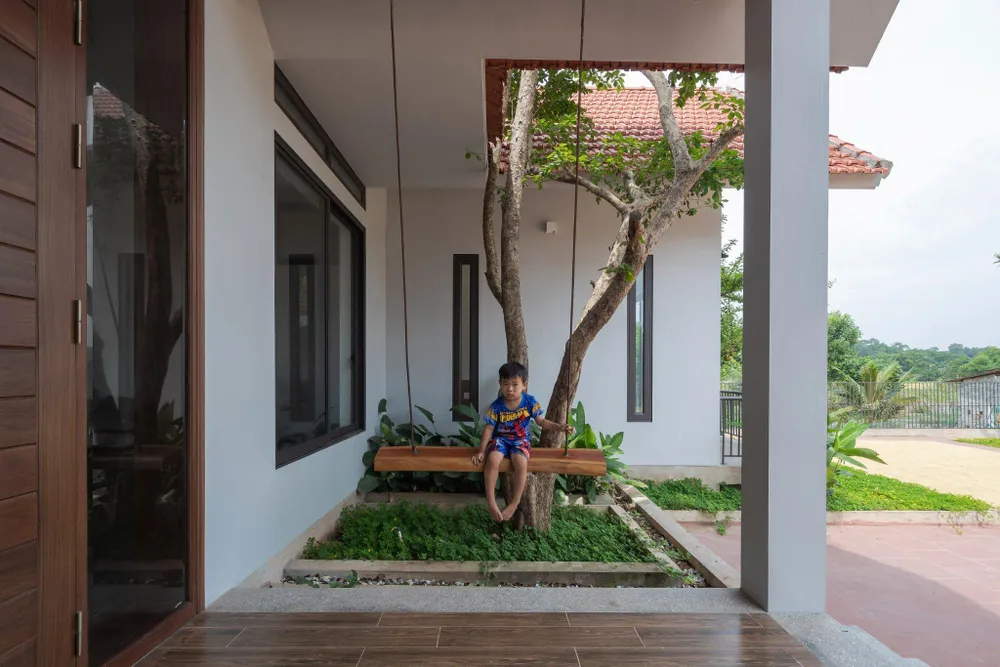 Xen kẽ giữa các gian nhà là hệ thống cây xanh lớn, tạo bóng mát cho ngôi nhà và khoảng sân vui chơi của con cái.