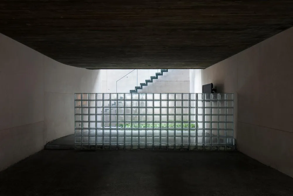 Lối cầu thang dẫn lên tầng thượng được ngăn cách bởi vách tường trong suốt.