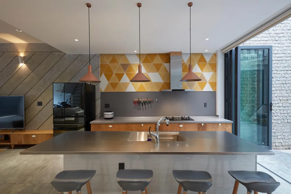 Phòng khách, bếp và bàn ăn thiết kế cạnh giếng trời.