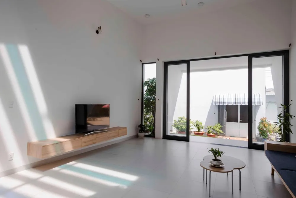 Bước vào bên trong căn nhà là một không gian thoáng đãng nhờ cách bố trí khéo léo để hứng trọn ánh sáng tự nhiên chiếu rọi và khoảng xanh với cây cối quanh nhà.