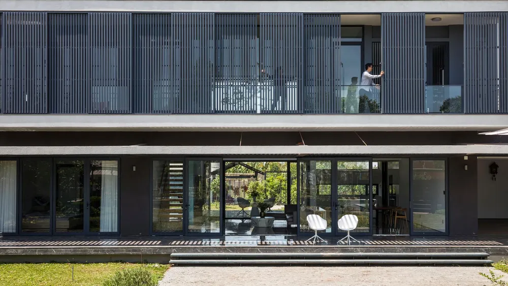 Hàng hiên dài không cột trở thành vùng đệm che nắng giảm nhiệt, tạo khu vực chuyển tiếp giữa không gian bên trong và bên ngoài.