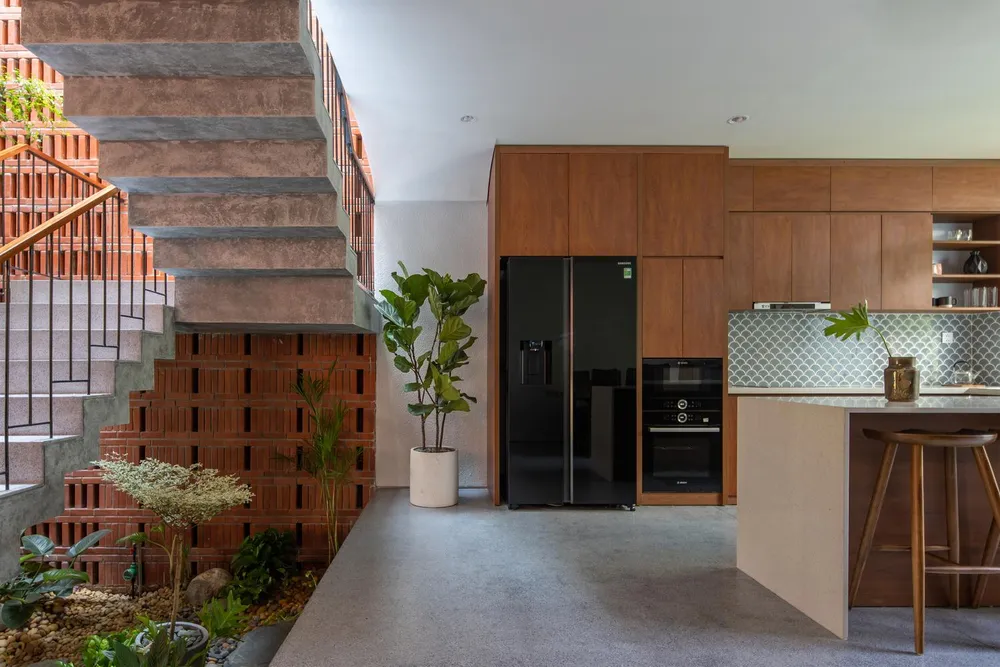 Phòng khách và bếp liên thông với nhau bằng giếng trời và khu vườn nhỏ ở giữa.