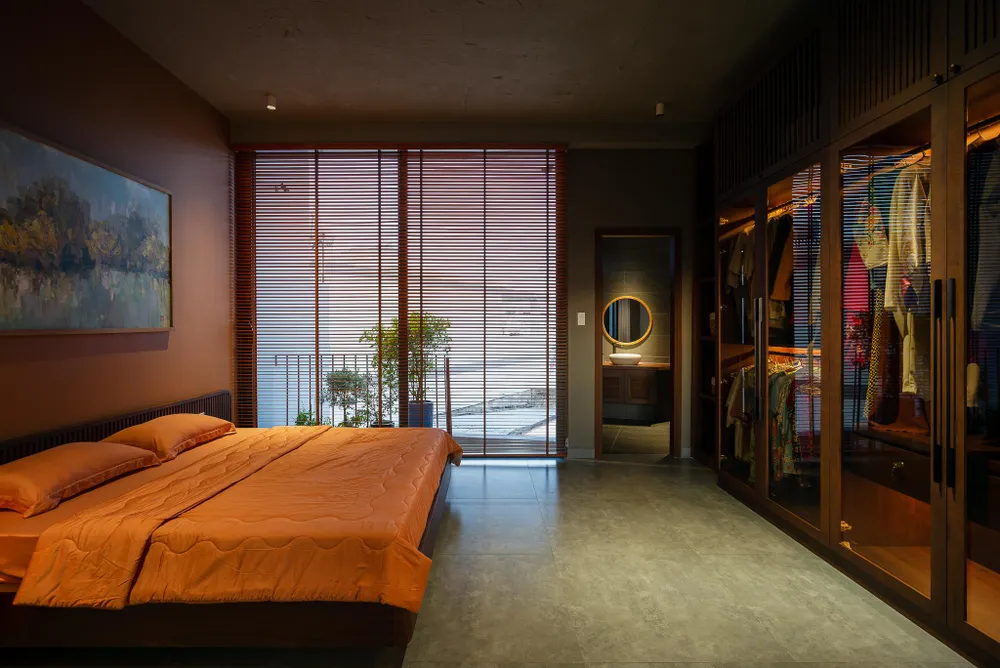 Phòng ngủ có tông màu cam, hệ tủ đựng đồ bằng kính.